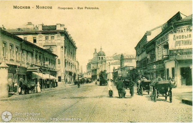 Altes Schwarz-Weiß-Foto einer Straßenansicht in Moskau, Russland, mit Menschen, Pferdewagen, Gebäuden, Namensschildern, Laternenpfählen und Himmel, mit Text oben und unten.