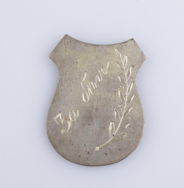 Silbernes Abzeichen mit Eichenlaubdesign, beschriftet mit "50. Hochzeitstag", vor einem weißen Hintergrund.