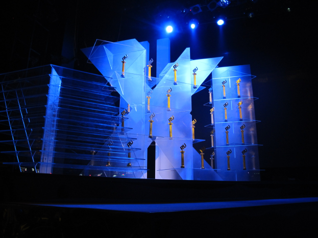 Eine dunkle Bühne mit minimaler Beleuchtung, die ein paar Gegenstände zeigt, die wahrscheinlich mit einer Preisverleihung zu tun haben.