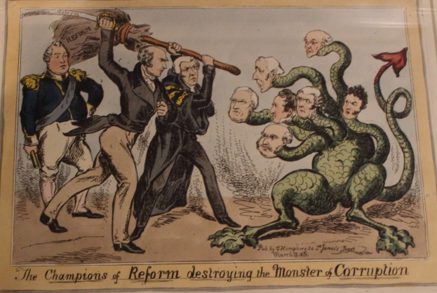 Ein Cartoon auf Papier zeigt Figuren, die als Reformchampions bezeichnet werden, die ein Monster, das als Korruption bezeichnet wird, angreifen, mit begleitendem Text, der "Die Reformchampions zerstören das Monster der Korruption" lautet.