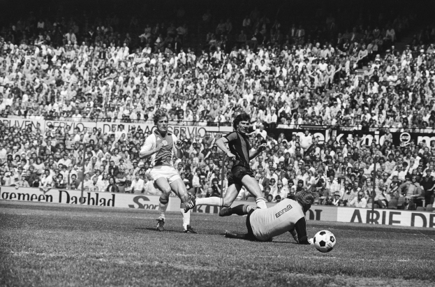 Schwarzes Foto von Fußballspielern auf einem Feld mit Zuschauern im Hintergrund und einer Bundesliga 1978-79 Ajax 1-1 Hannover 96-Tafel.