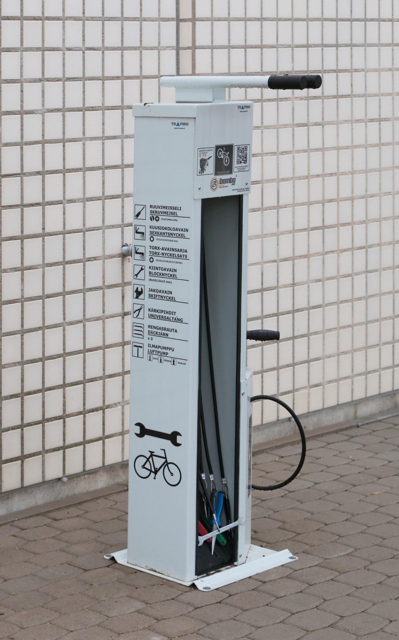 Ladestation für Elektrofahrzeuge mit einer bodengestützten Maschine und einer Gebäudewand im Hintergrund.