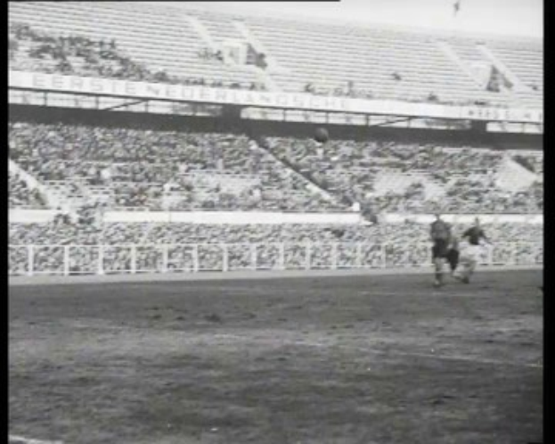 Schwarzes und weißes Foto eines Fußballspiels in einem Stadion während des Finals der näheren Fußballliga der Niederlande 1961-1962, mit Spielern auf dem Feld und Zuschauern in den Rängen.