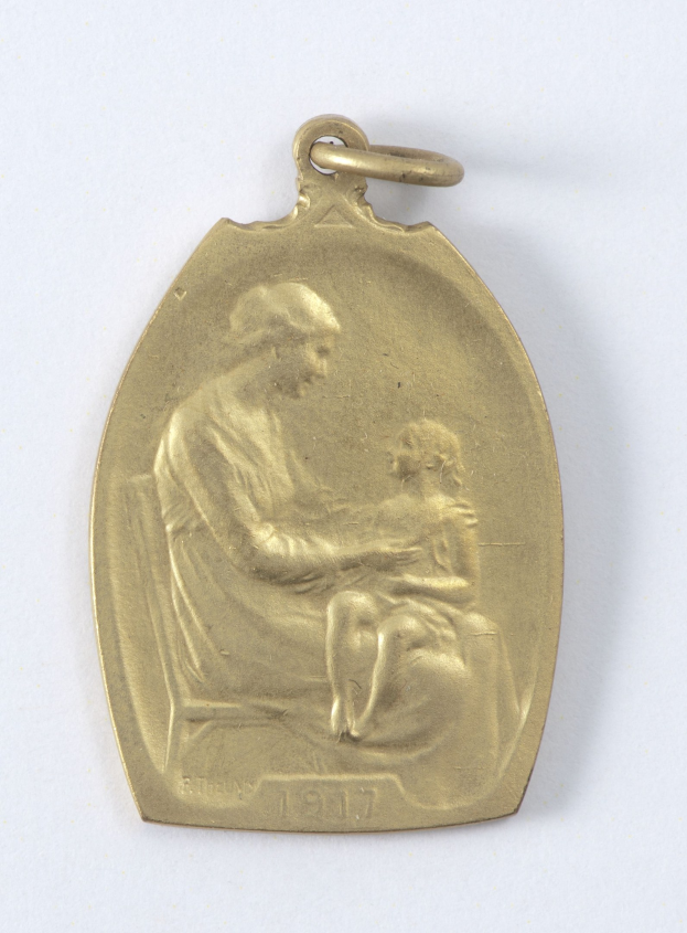 Goldmedaille mit Relief einer Frau in weißem Kleid mit Haarknoten, die ein Kind hält, beide schauen sich sanft an, beschriftet mit 'Mutter und Kind' in Kursivschrift.