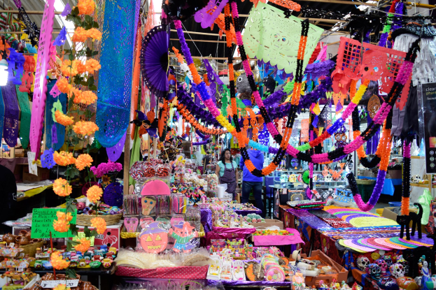 Ein belebter Markt mit Ständen, die Spielzeug, Dekorationsgegenstände und andere Gegenstände verkaufen, unter einer mit Lichtern geschmückten Decke, mit Menschen, die herumlaufen.