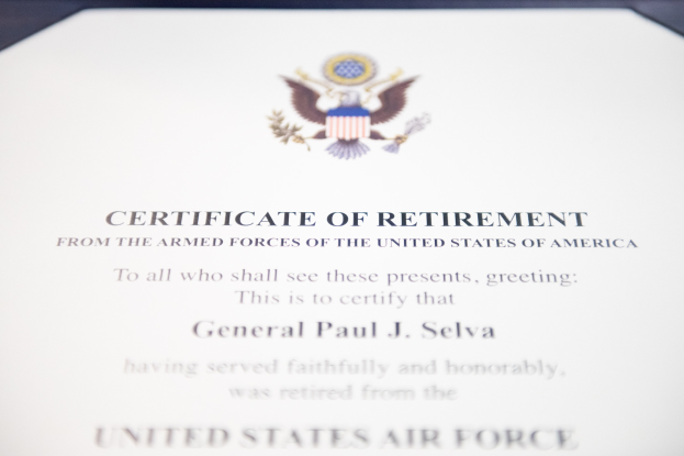 Rahmenurkunde über den Ruhestand der United States Air Force mit blauem Rand, die ein zentrales Sternschild-Logo zeigt, umgeben von einem Lorbeerkranz und einer "Ruhestand"-Bannerschrift in Schwarz.