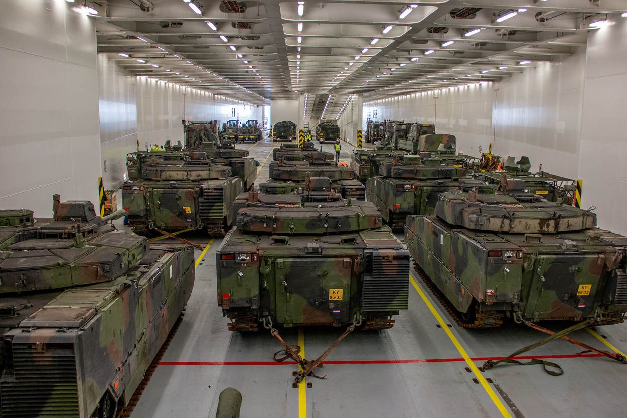 Ein grosser Militaraerraum mit zahlreichen Tanks, die in einer ordentlichen Reihe angeordnet sind und von einer Decke mit Lampen uberstrahlt werden.