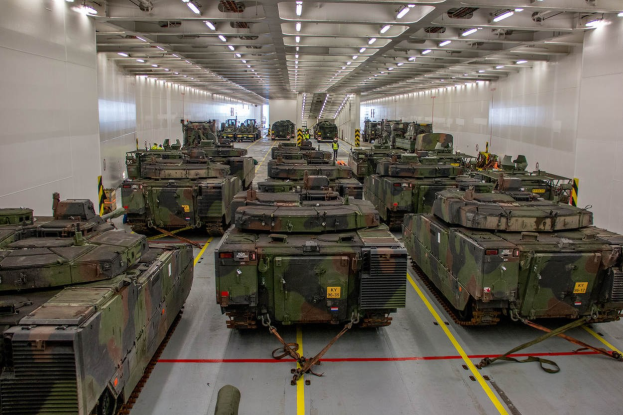 Ein grosser Militaraerraum mit zahlreichen Tanks, die in einer ordentlichen Reihe angeordnet sind und von einer Decke mit Lampen uberstrahlt werden.