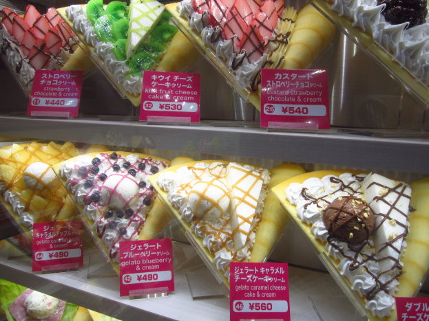 Vitrine voller verschiedener Eissorten, jede mit einem Preisschild, sortiert nach Farbe, Form und Geschmack.