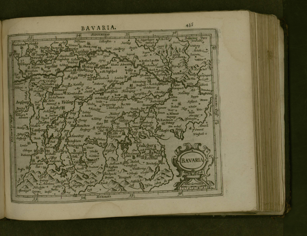 Ein aufgeschlagenes Buch, das eine detaillierte Karte von Bayern mit beschrifteten St├Ądten und Ortschaften zeigt, begleitet von beschreibendem Text.